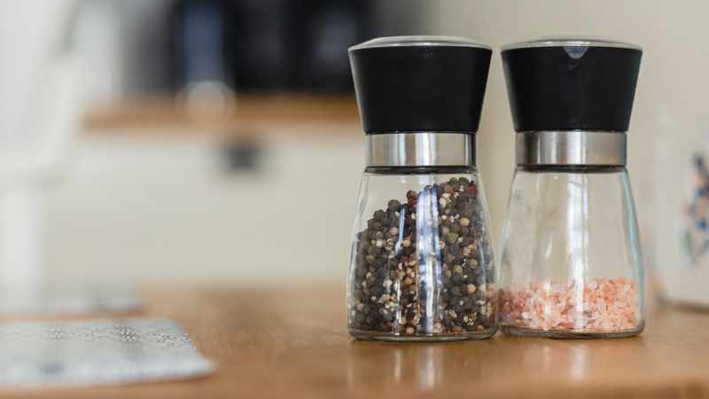 Zwei Gewürzmühlen mit Pfeffer und Salz